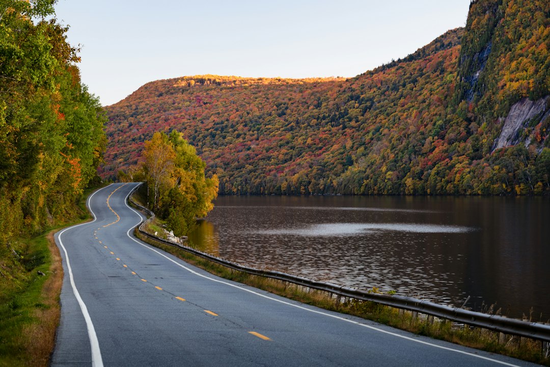 Winding autumn highway past a colorful mountain lake