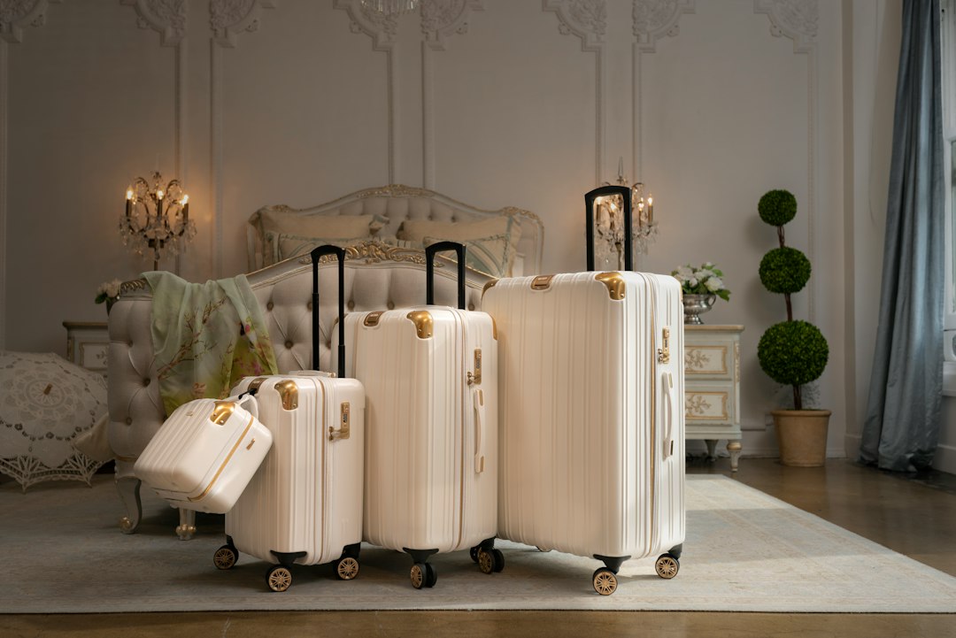 A set of hardshell suitcases lined up in a bedroom before a trip