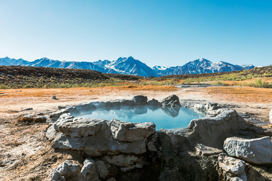 Hikers approaching steaming pools built into a mountainside