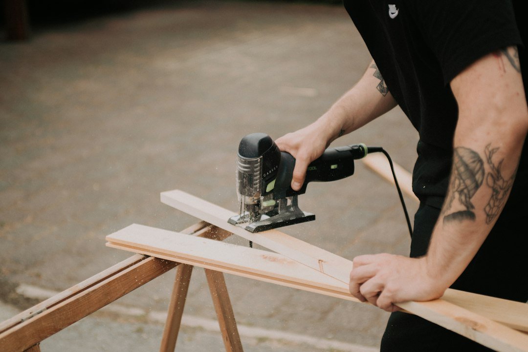 Cutting plywood with a jigsaw on sawhorses in a workshop