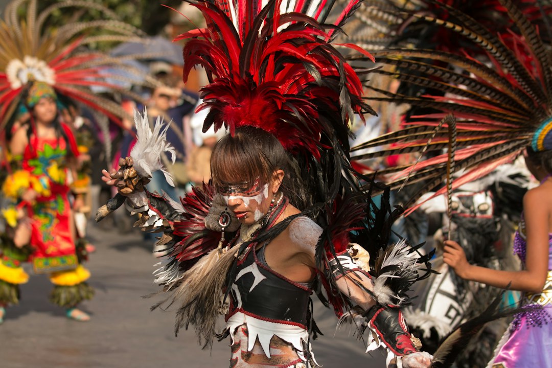 Dancer in feathered headdress performing in a comparsa street parade