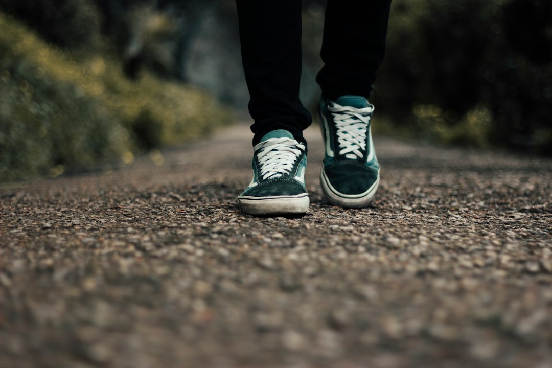 Feet in comfortable sneakers on a gravel path
