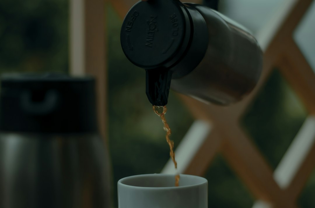 Pouring hot coffee from a thermos on a cold morning