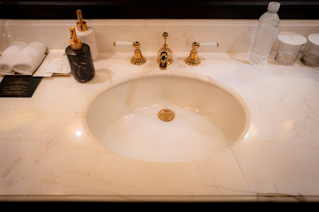 Hotel bathroom vanity with sink and gold fixtures