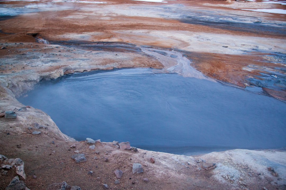 Steam rising from a geothermal pool under a night sky