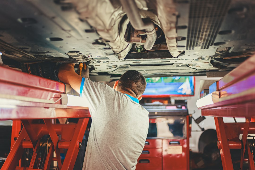 Mechanic working underneath a vehicle on a lift
