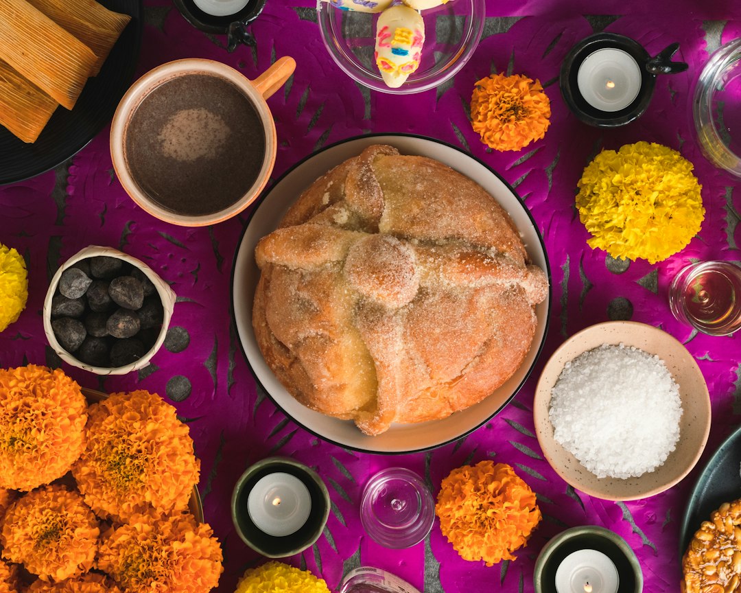 Day of the Dead ofrenda with pan de muerto, marigolds, tamales, and candles