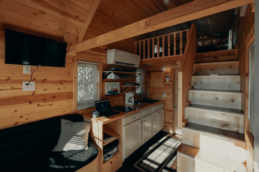 Warm wooden interior of a small camper with built-in seating and natural light
