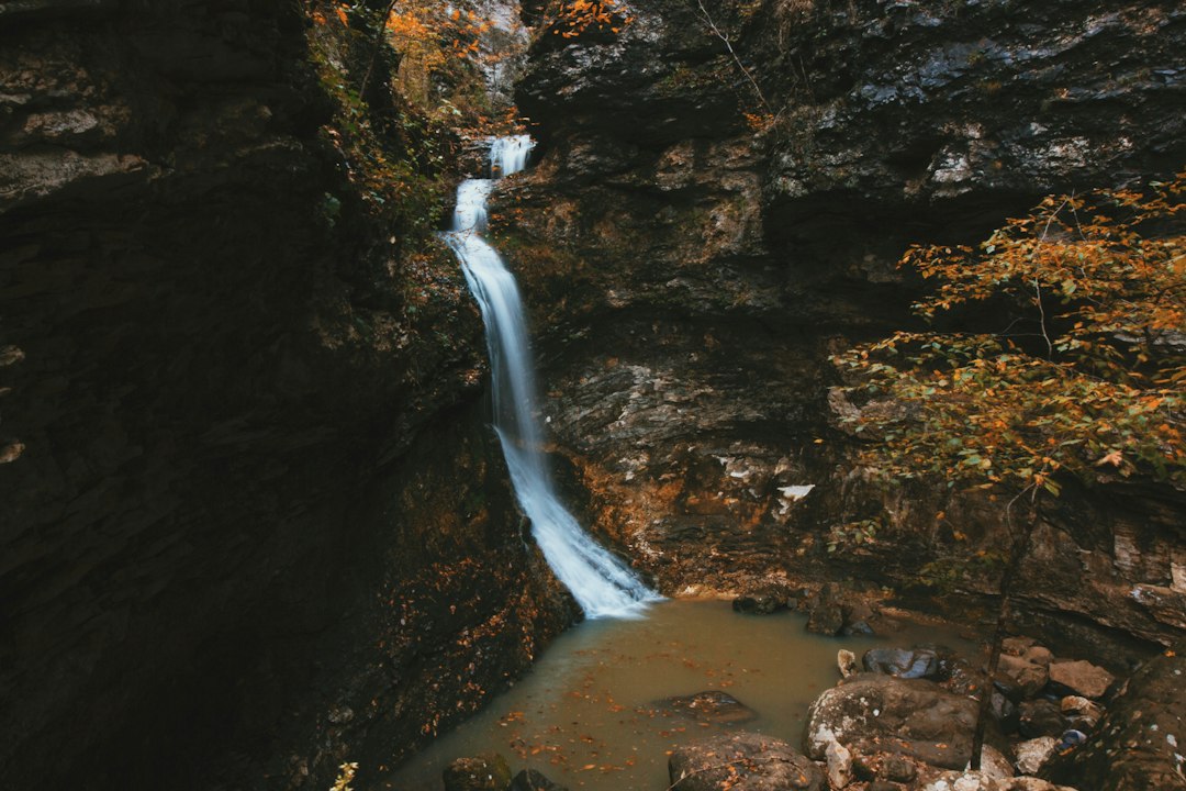 Waterfall dropping into an autumn gorge