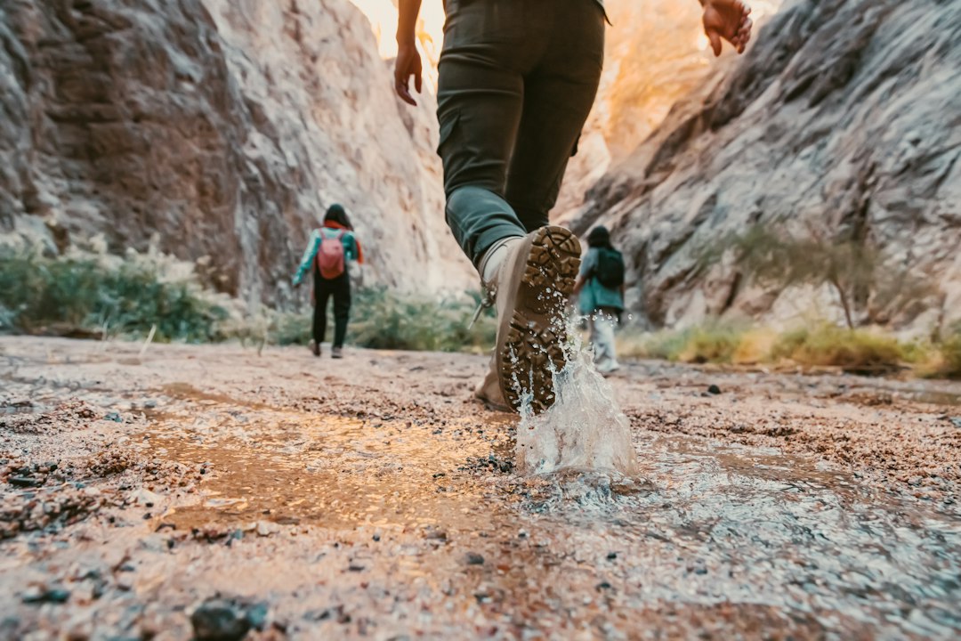 Hiker in sturdy boots stepping along a rocky desert trail